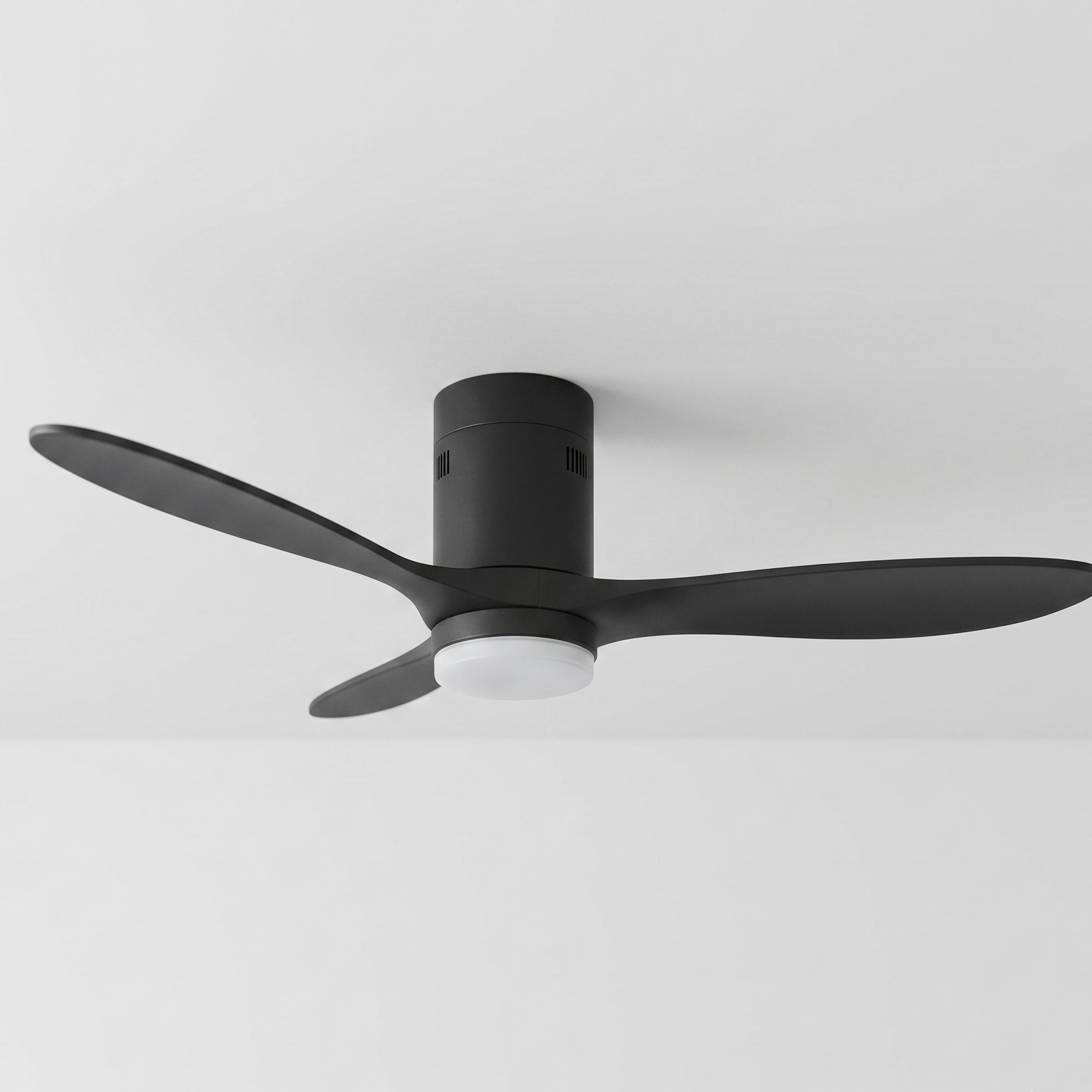 Ventilador de techo negro con tres aspas y luz integrada en techo blanco.