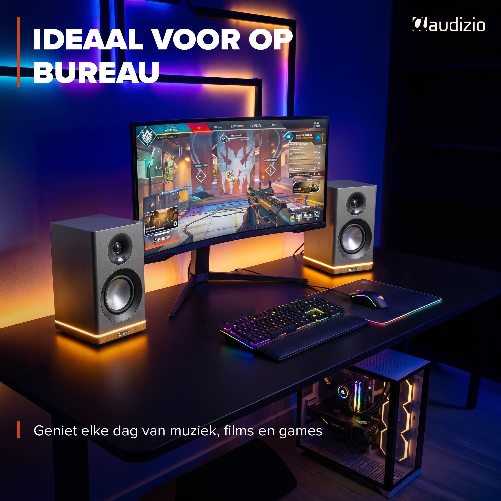 Un escritorio con monitor, teclado, ratón y altavoces, iluminado.