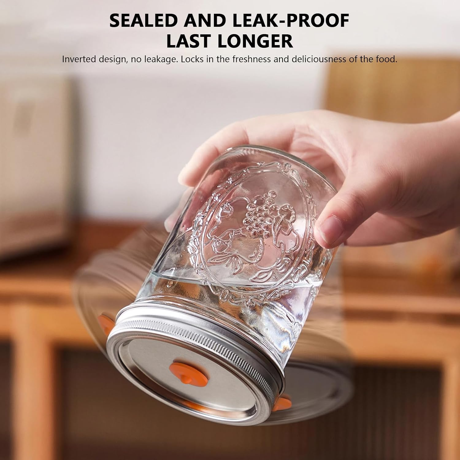 Hand hält ein Glas mit silbernem Deckel und offenem Orangenventil. Wasser darin.