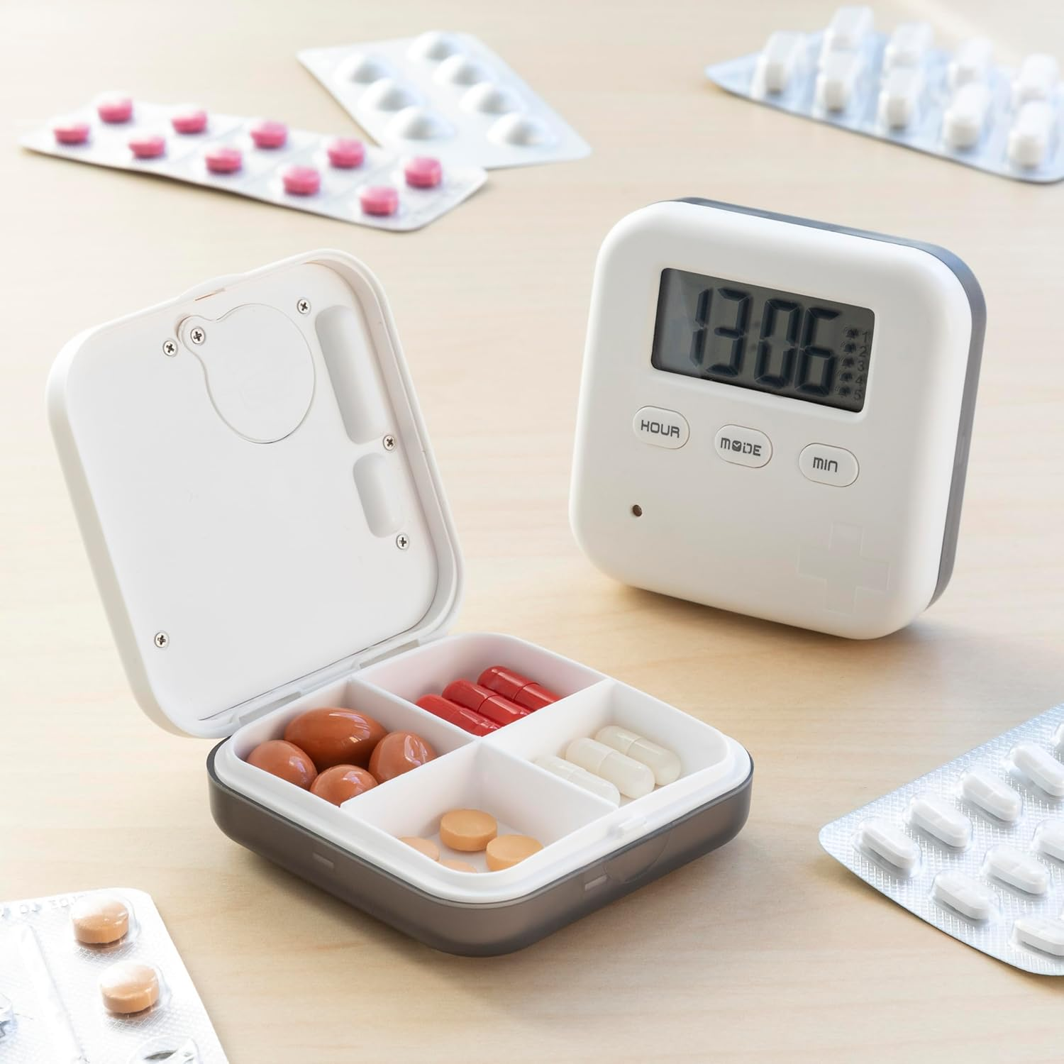 Ein Pillenorganisator mit braunen, roten und weißen Pillen und einer Digitaluhr.