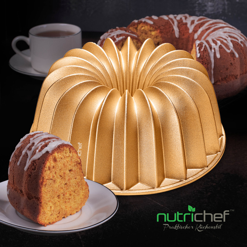 Eine goldene Gugelhupfform hält ein Kuchenstück. Dahinter steht ein weiterer Kuchen.