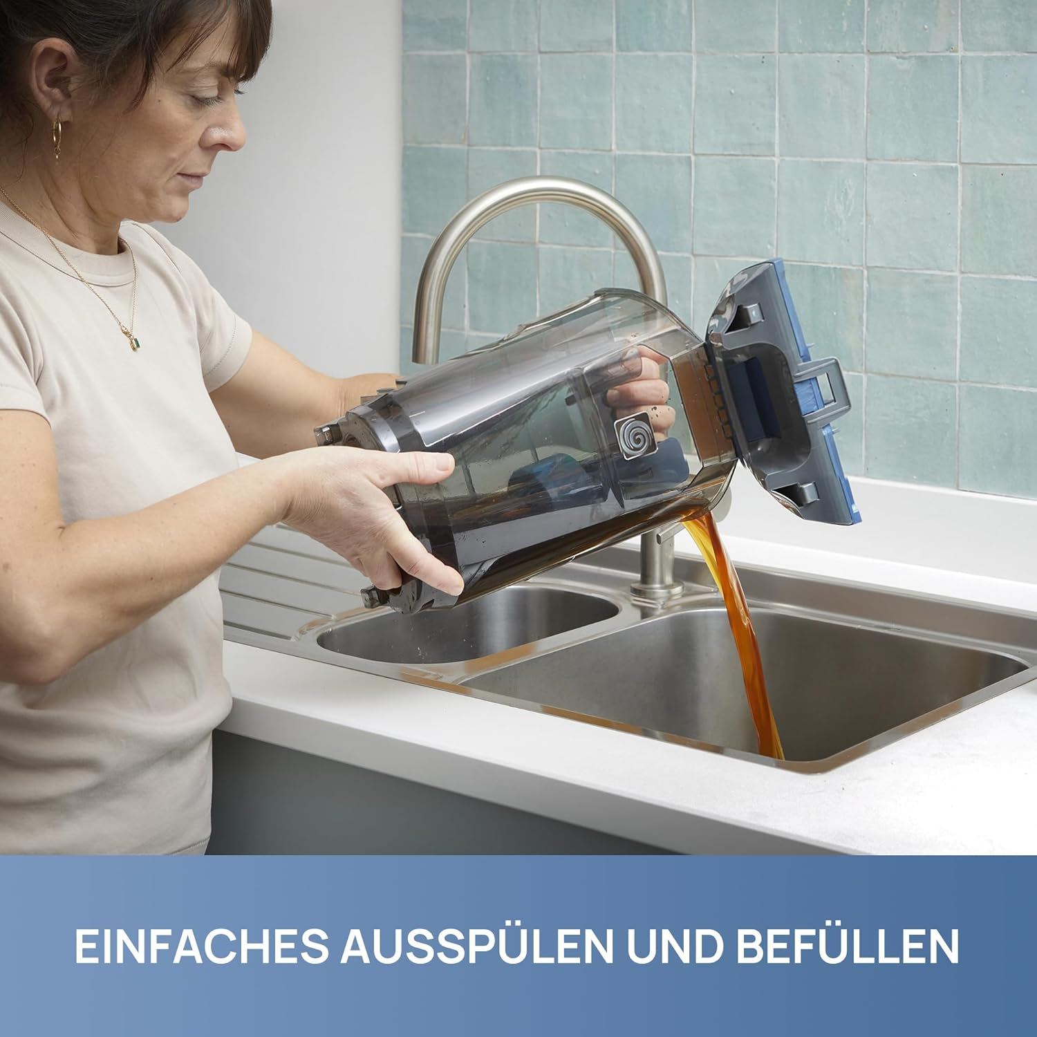 Frau spült Staubsaugerbehälter über dem Spülbecken aus.