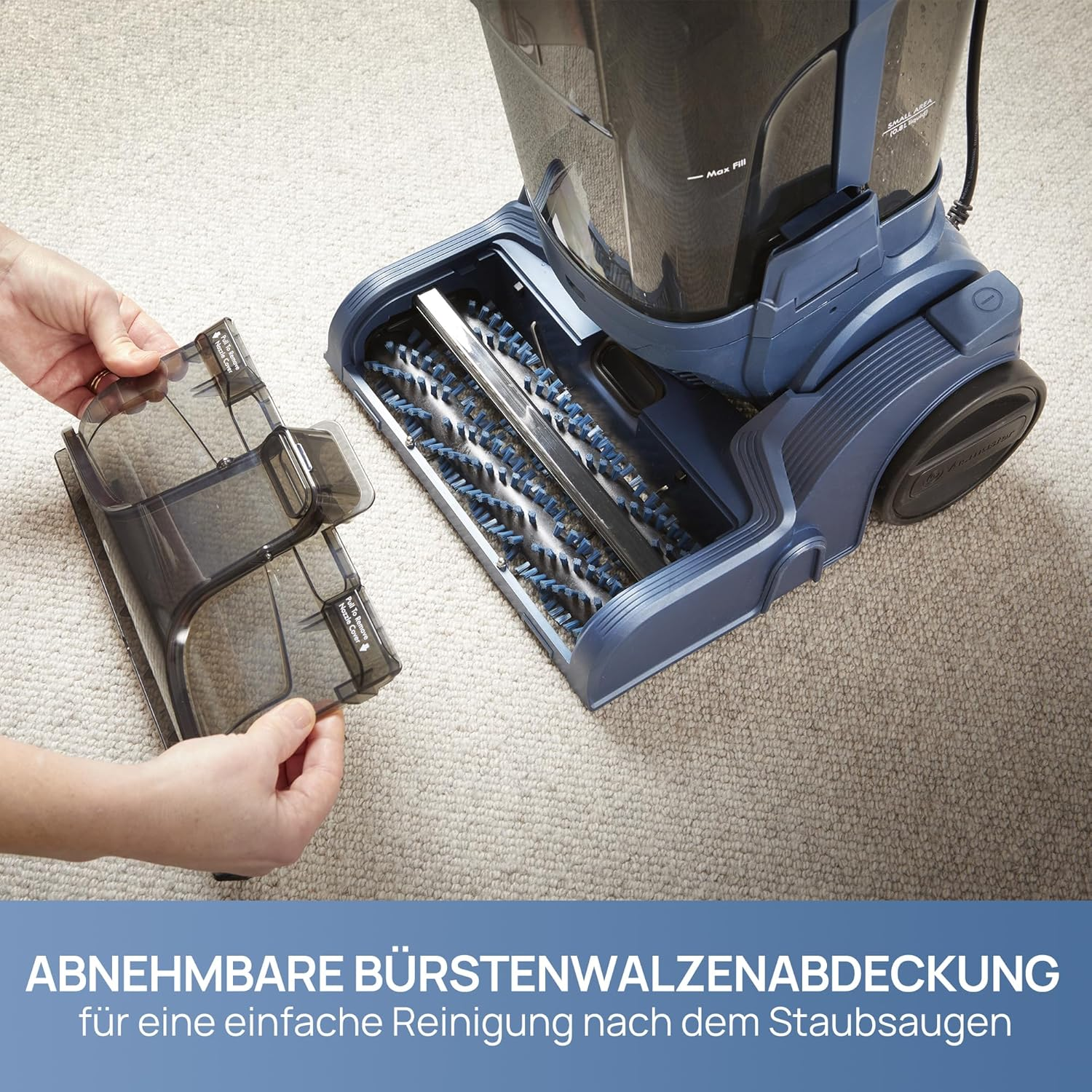 Eine Hand hält eine abnehmbare Bürstenwalzenabdeckung über einem Staubsauger.