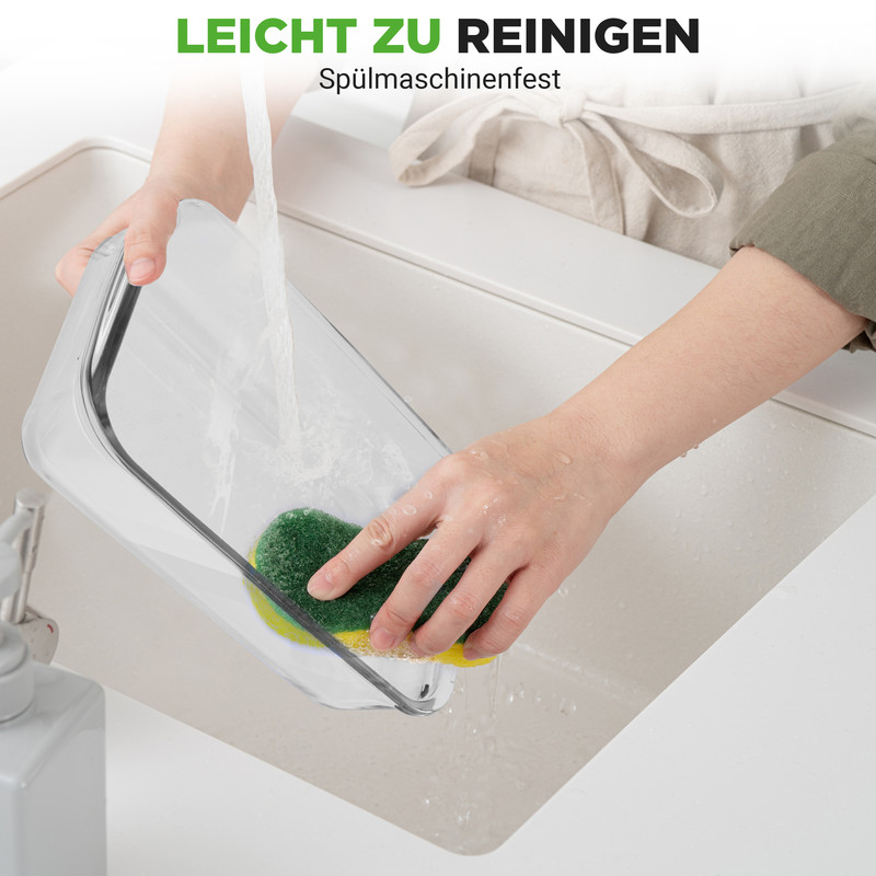 Eine Hand reinigt eine durchsichtige Schale mit einem grünen Schwamm unter fließendem Wasser.