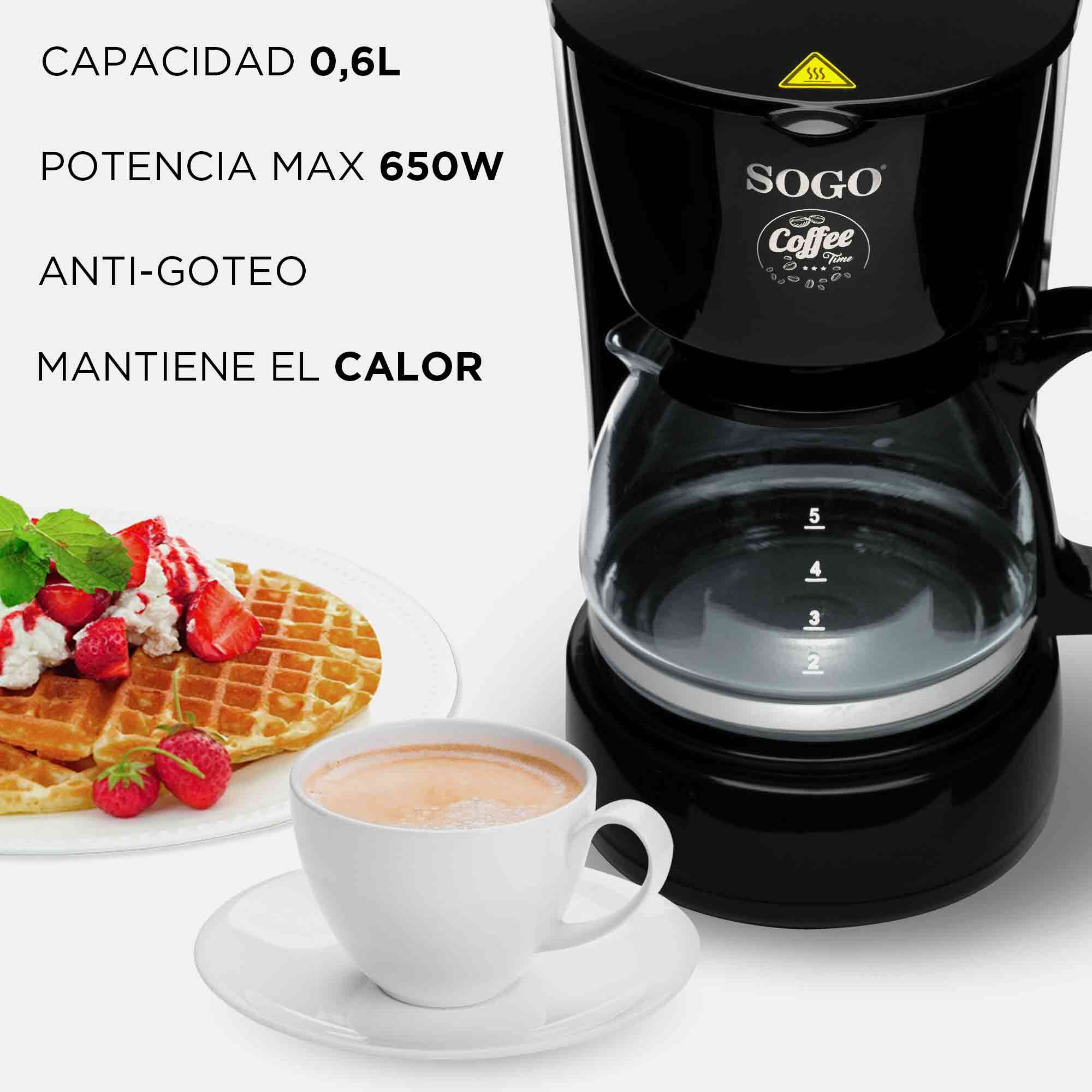 Caffettiera nera con caraffa in vetro, accanto a waffle con fragole e una tazza di caffè.