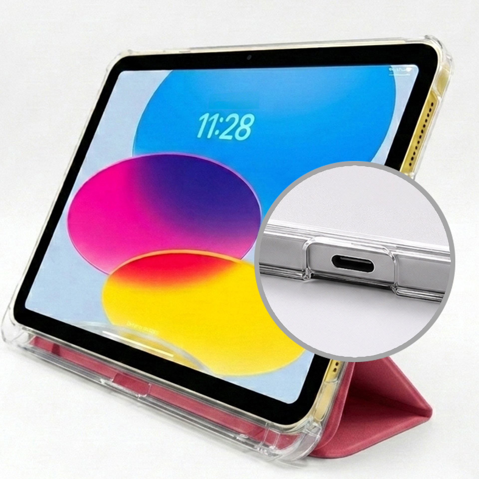 Tablet w przezroczystym etui z czerwonym stojakiem. Ekran pokazuje kolorowe koła i godzinę 11:28.