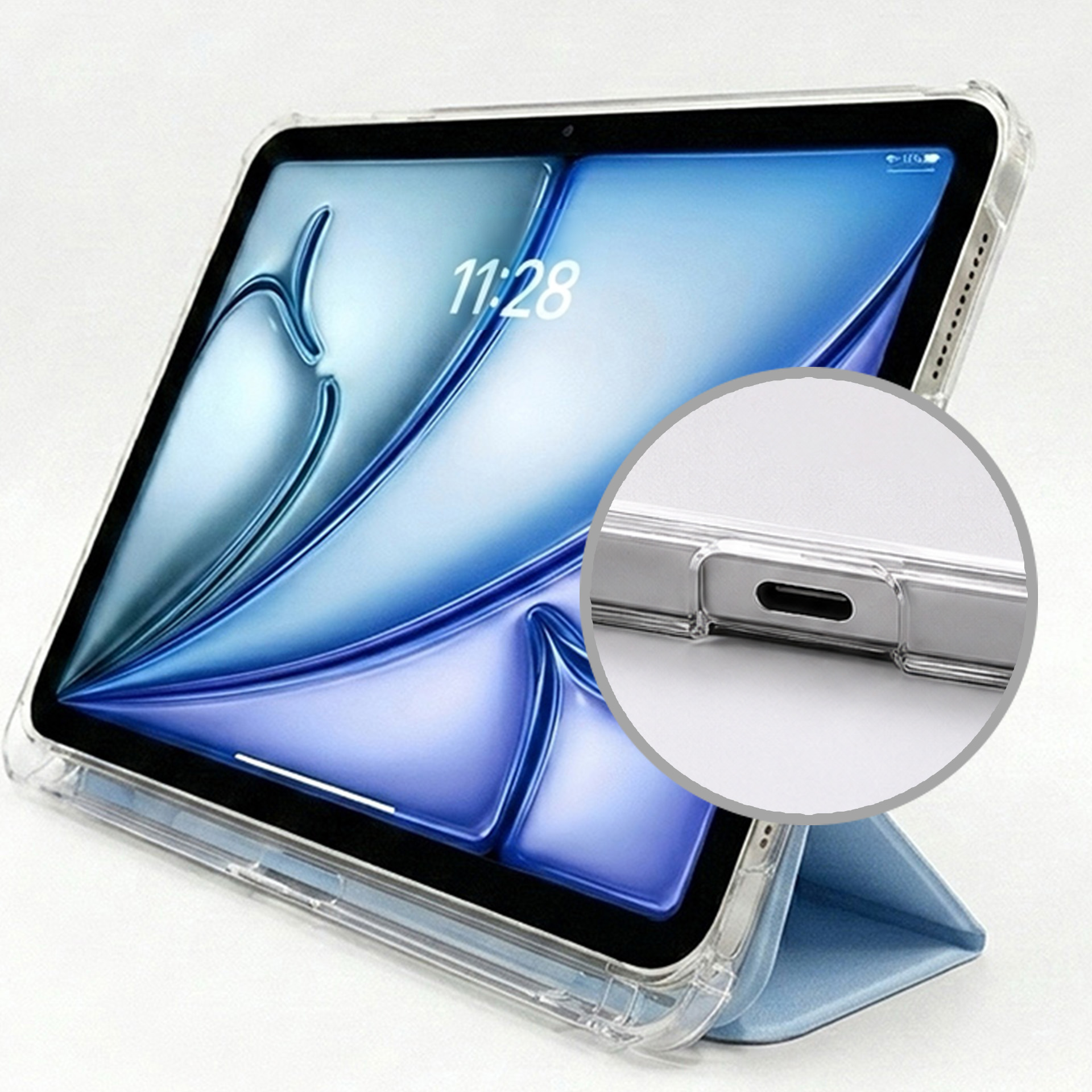 Tablet w przezroczystym etui, oparty na niebieskiej okładce. Zbliżenie portu ładowania.