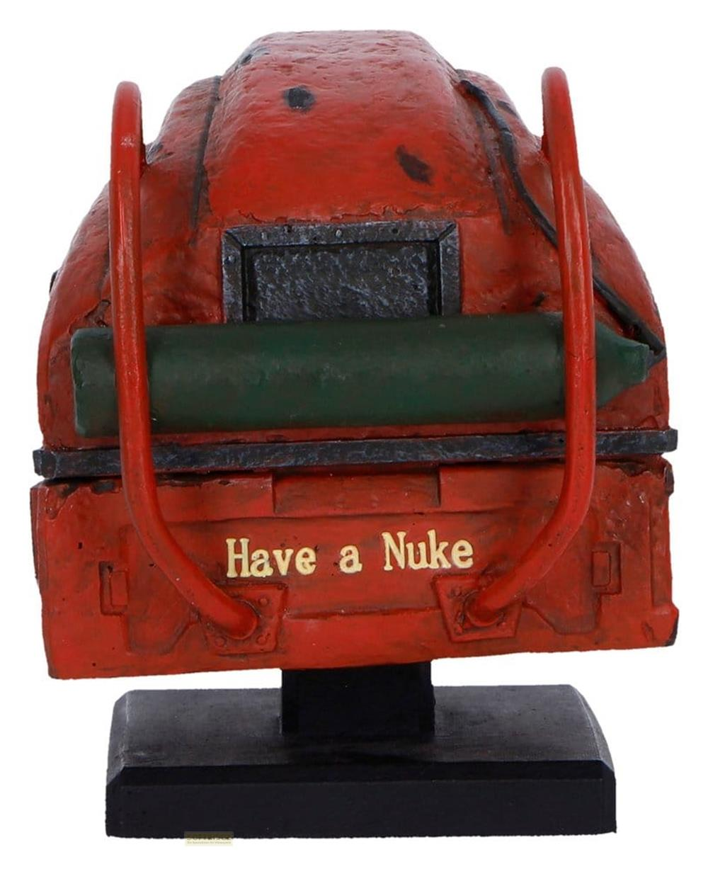 Ein roter, verwitterter Rucksack mit einem grünen Zylinder und goldener Schrift 'Have a Nuke'.