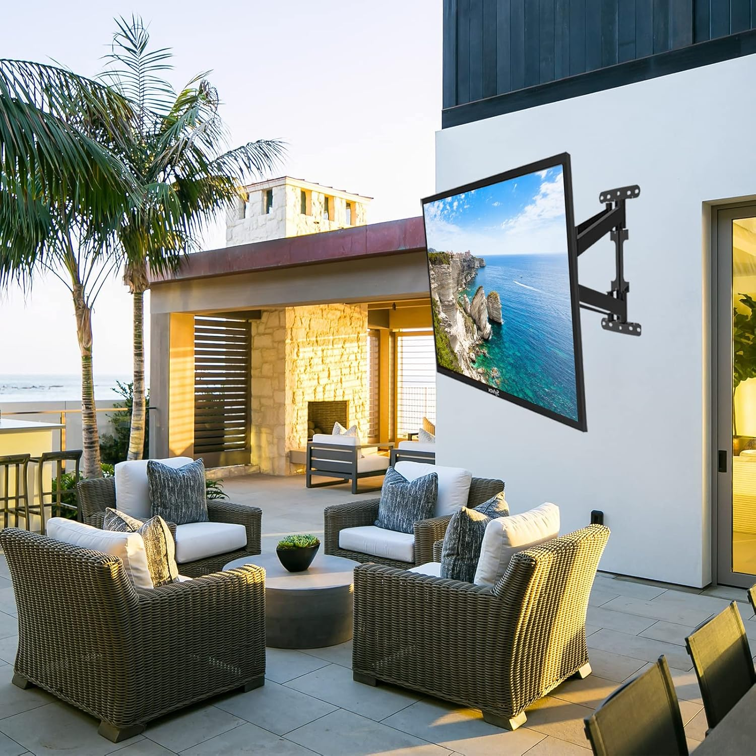Eine überdachte Terrasse mit Möbeln und einem Fernseher an der Wand.