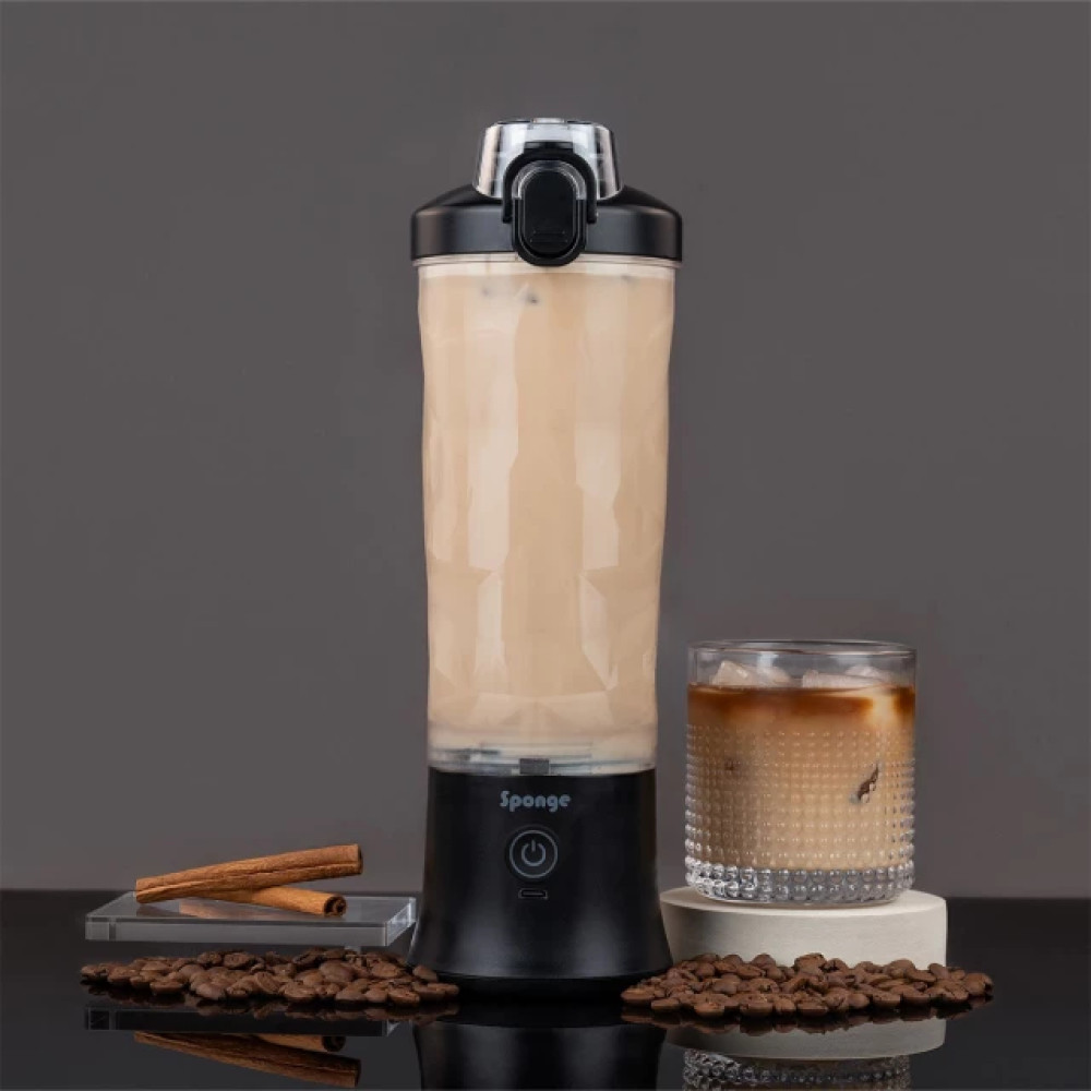 Wysoki blender z kremowym napojem i lodem stoi obok szklanki kawy mrożonej.
