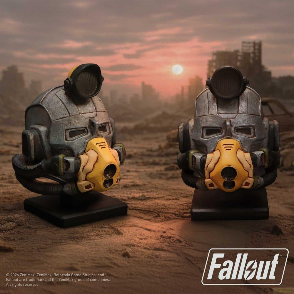Zwei Fallout-Helme mit gelben Masken und Gasmasken, die in einer Wüstenlandschaft ausgestellt sind.
