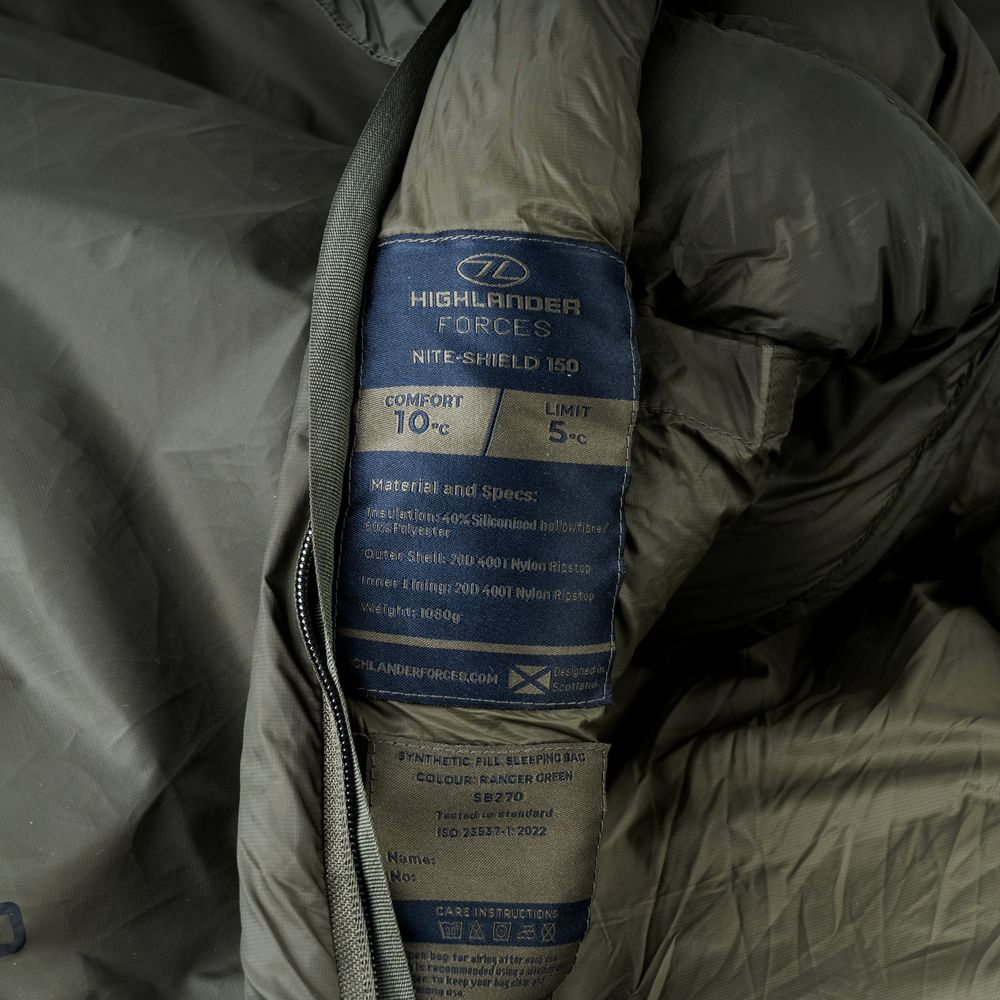 Dunkelgrüner Schlafsack mit Etiketten, die Details zu Komfort, Material und Gewicht anzeigen.
