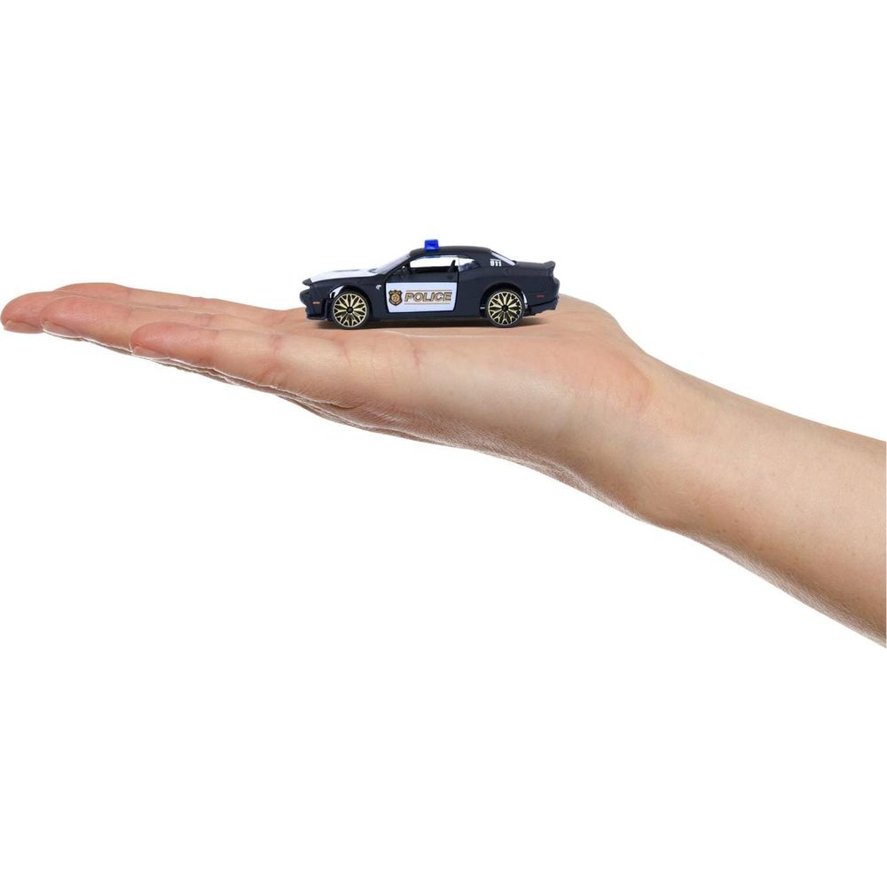 Ein dunkles Spielzeugpolizeiauto mit Blaulicht auf einer Hand.