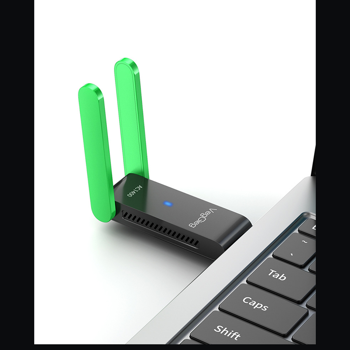 Ein schwarzer WLAN-Adapter mit zwei grünen Antennen steckt in einem Laptop.