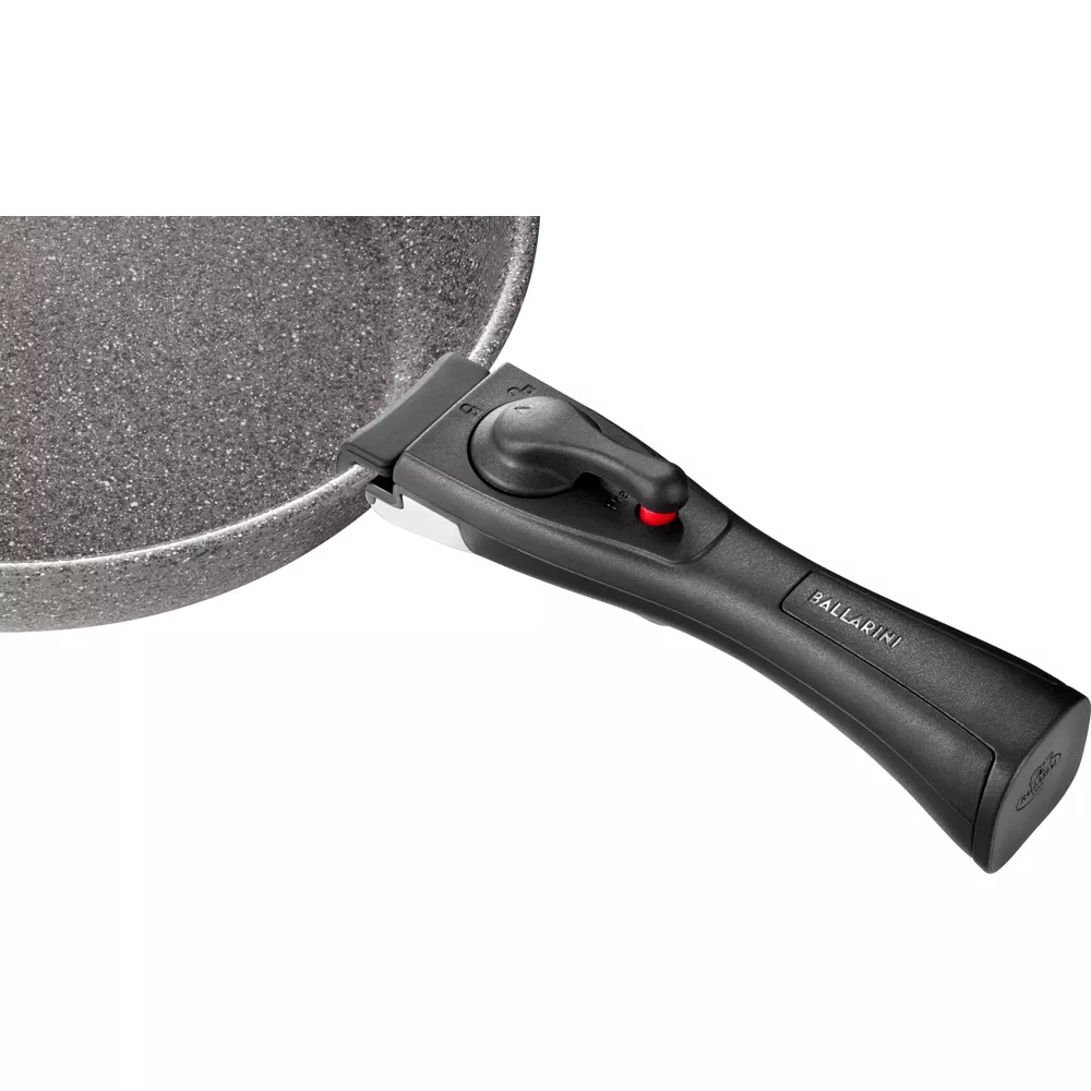 Padella grigia con manico nero rimovibile e pulsante rosso.