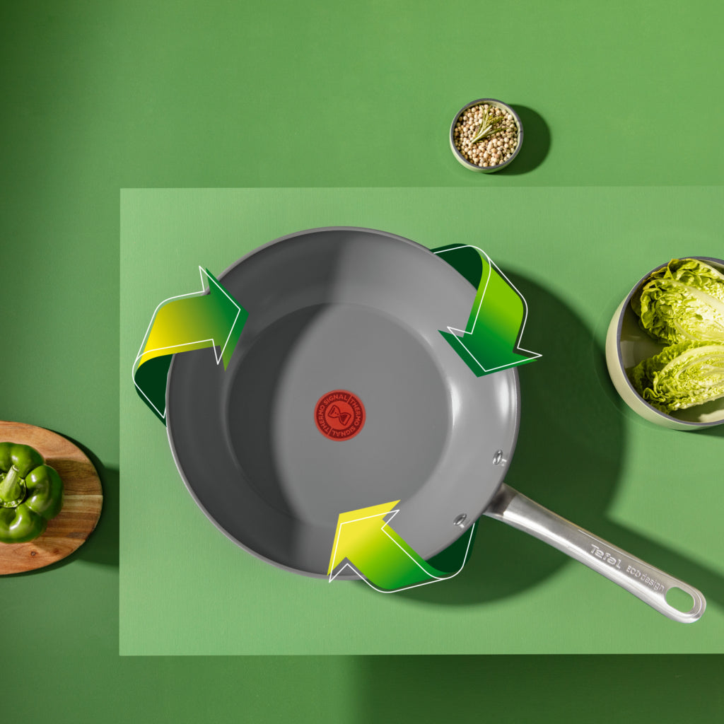 Padella grigia con frecce verdi, peperone verde, lattuga e semi.