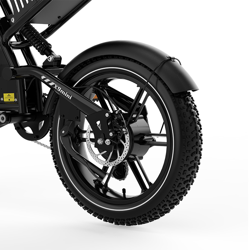 Rueda trasera de una e-bike negra con freno de disco, amortiguador y guardabarros.