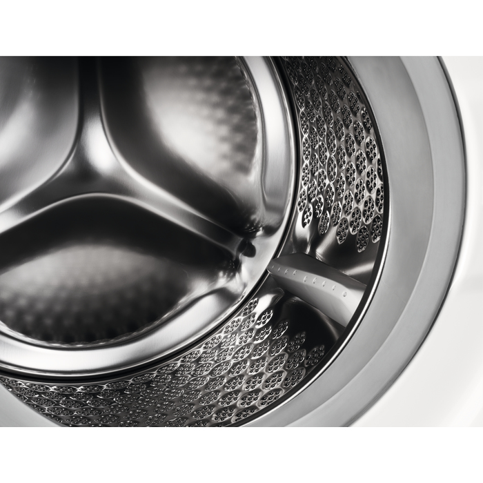 Close-up van een glanzende metalen trommel van een wasmachine met kleine geperforeerde patronen.