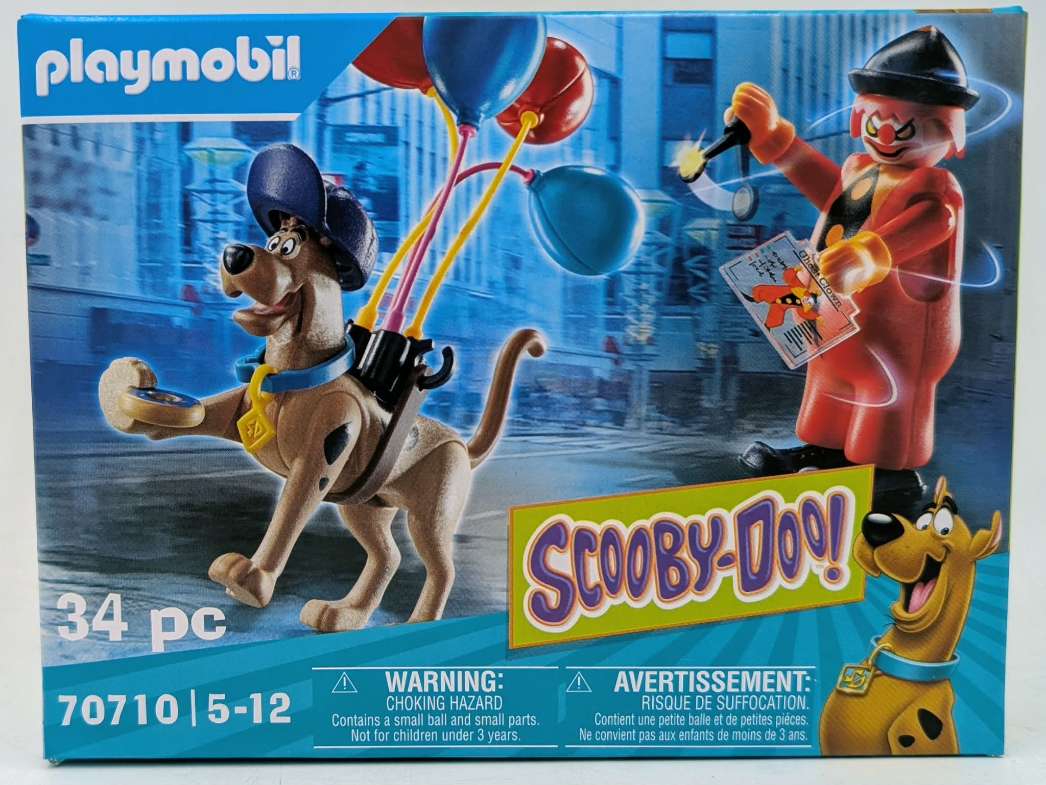 Pudełko z zabawkami Playmobil Scooby-Doo! ze Scooby-Doo i klaunem trzymającym ducha na bilecie.