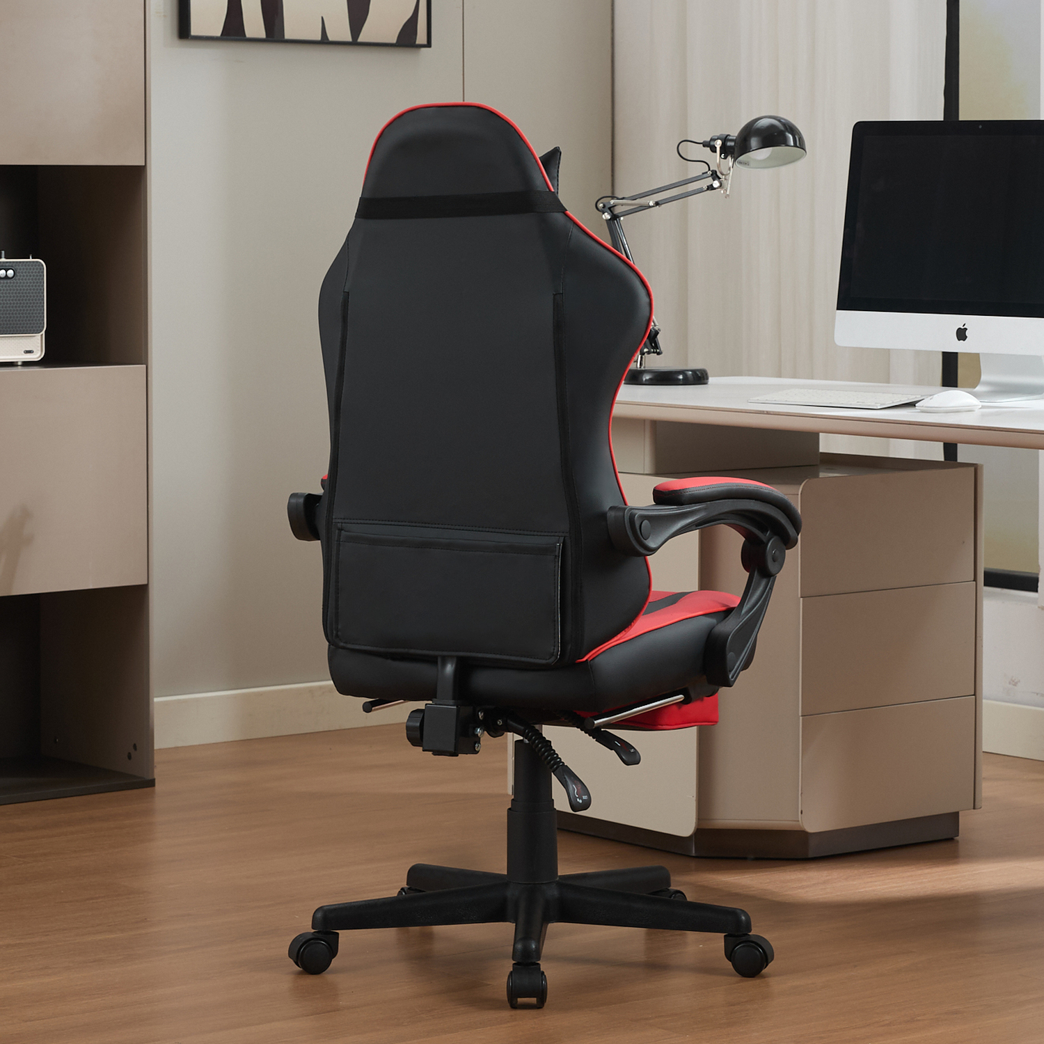Schwarzer Gaming-Stuhl mit roten Akzenten, Blick von hinten, im Büro.