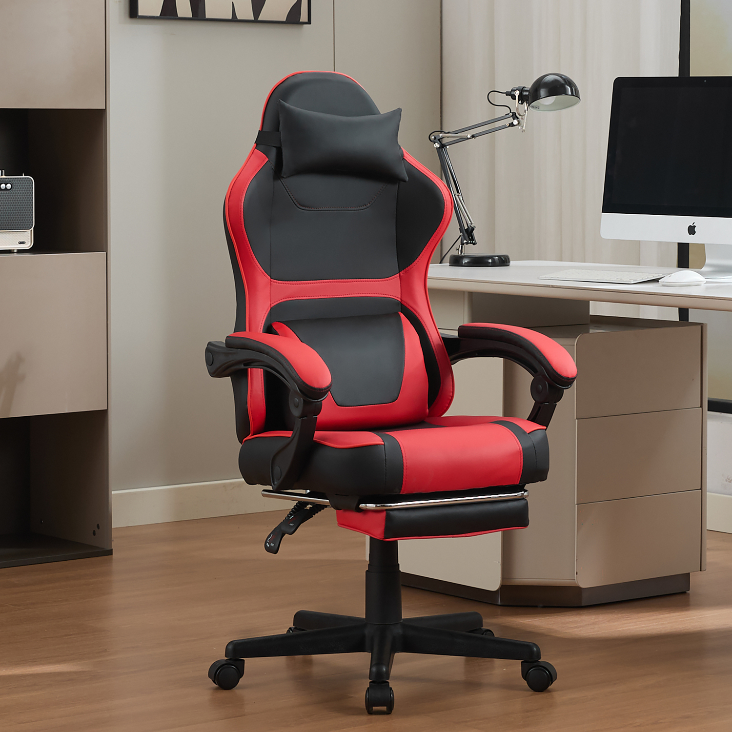 Ein roter und schwarzer Gaming-Stuhl mit Fußstütze steht vor einem Schreibtisch mit Computer.