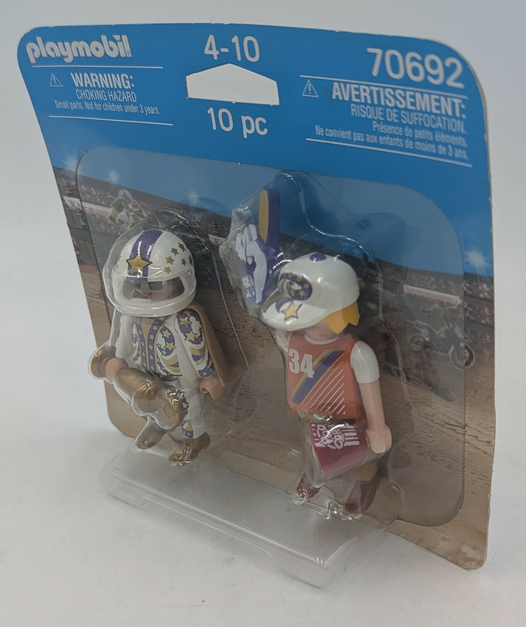 Personaggi Playmobil in tuta da corsa con caschi, confezionati su un cartone a tema corse.