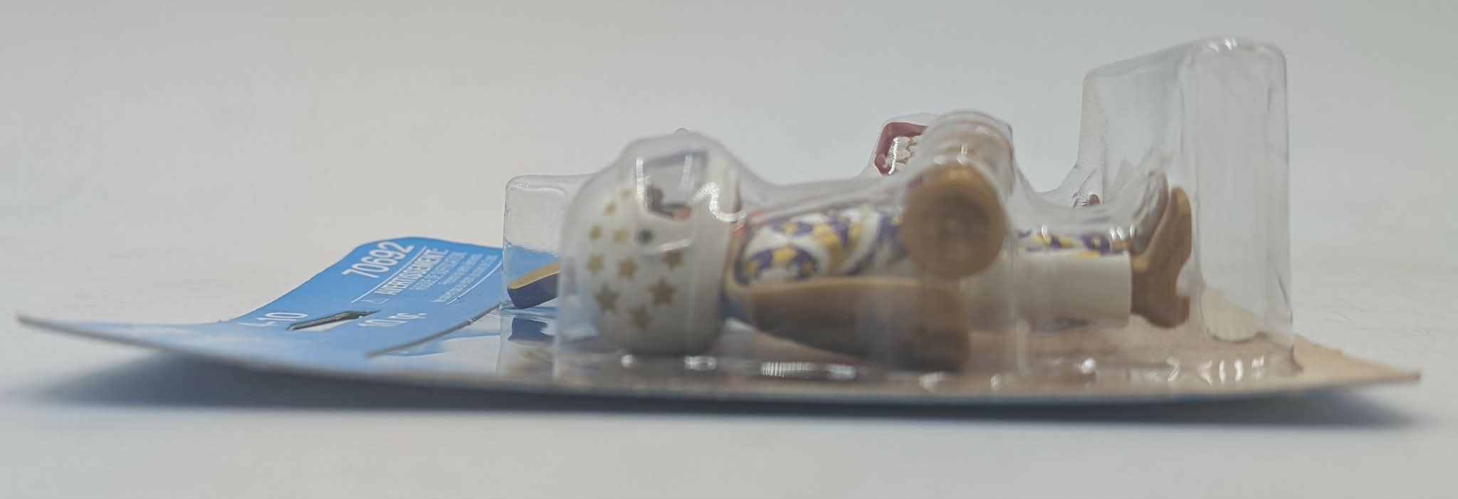 Un giocattolo in blister di plastica, con motivo a stelle e accenti viola.