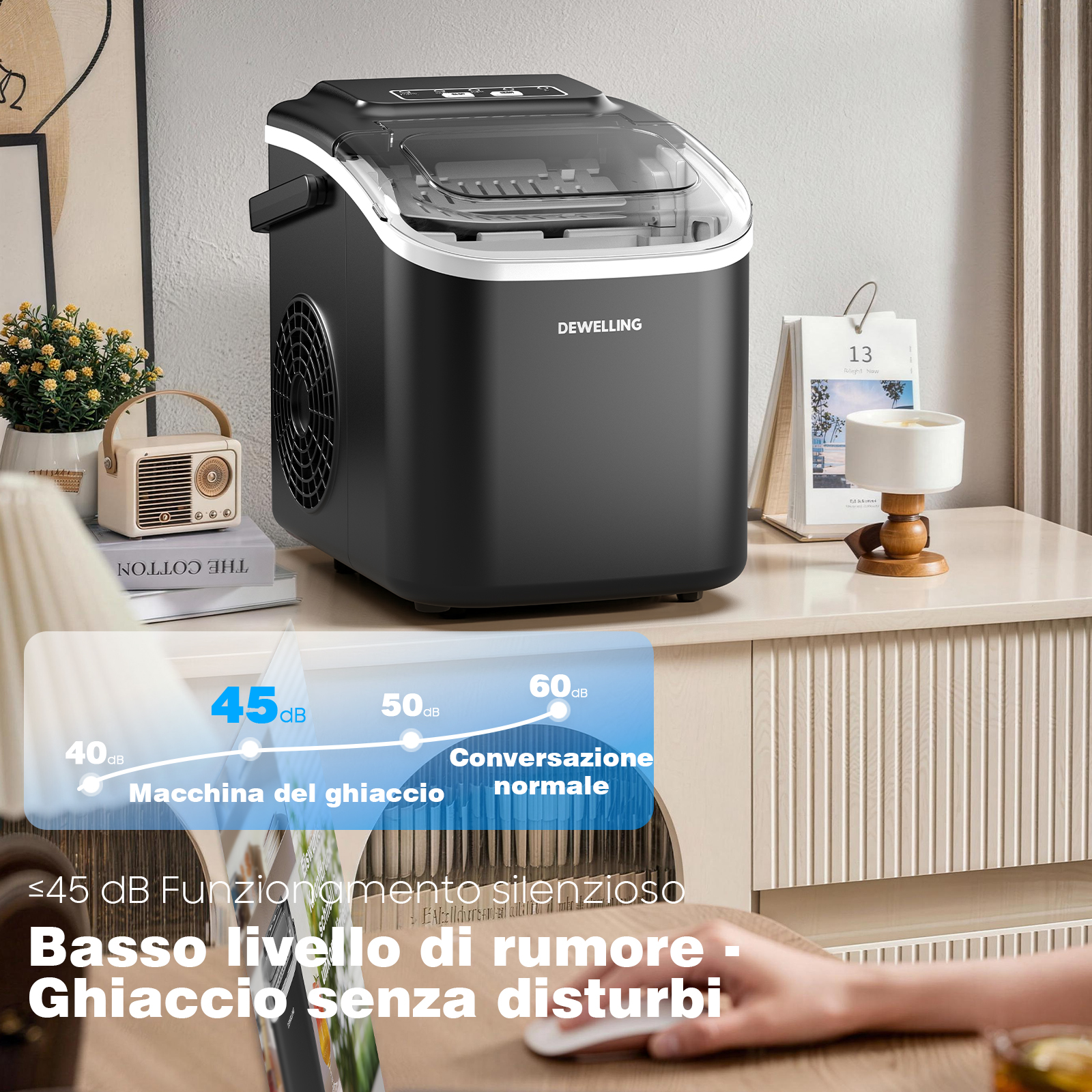Una macchina del ghiaccio nera DEWELLING è su un tavolo accanto a una pianta e un calendario.