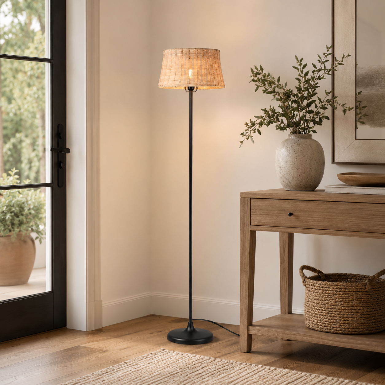 Una lámpara de pie con pantalla de mimbre junto a una mesa consola de madera con jarrones.