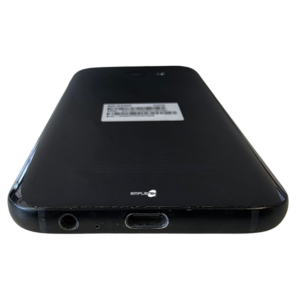 Smartphone nero dal basso, con jack per cuffie e porta di ricarica.