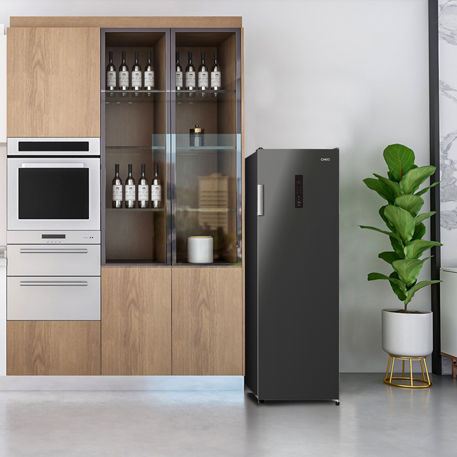 Cocina moderna con gabinetes de madera, hornos empotrados, refrigerador oscuro y planta en maceta.
