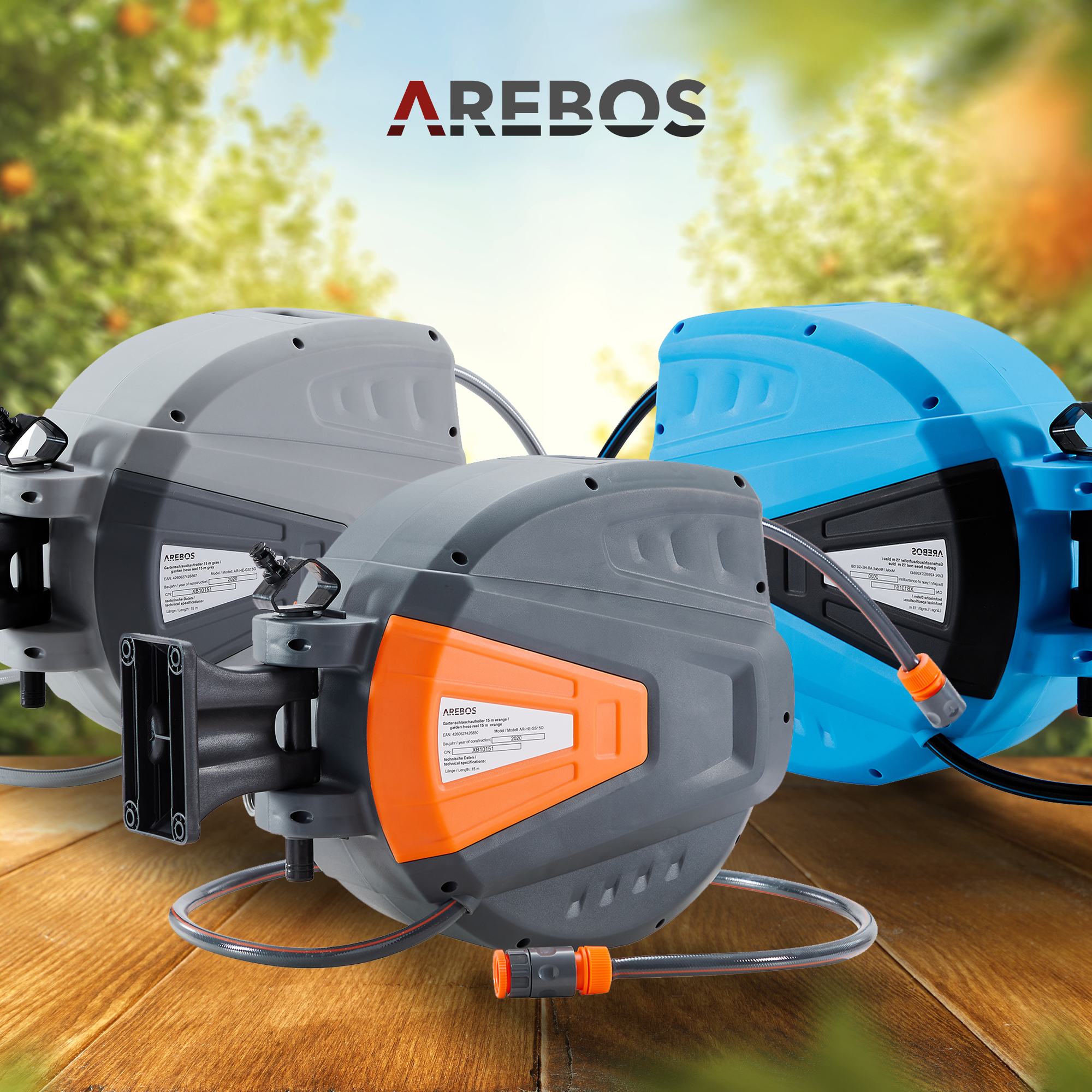 Drei AREBOS Gartenschlauchaufroller in Grau, Orange und Blau auf einem Holztisch.