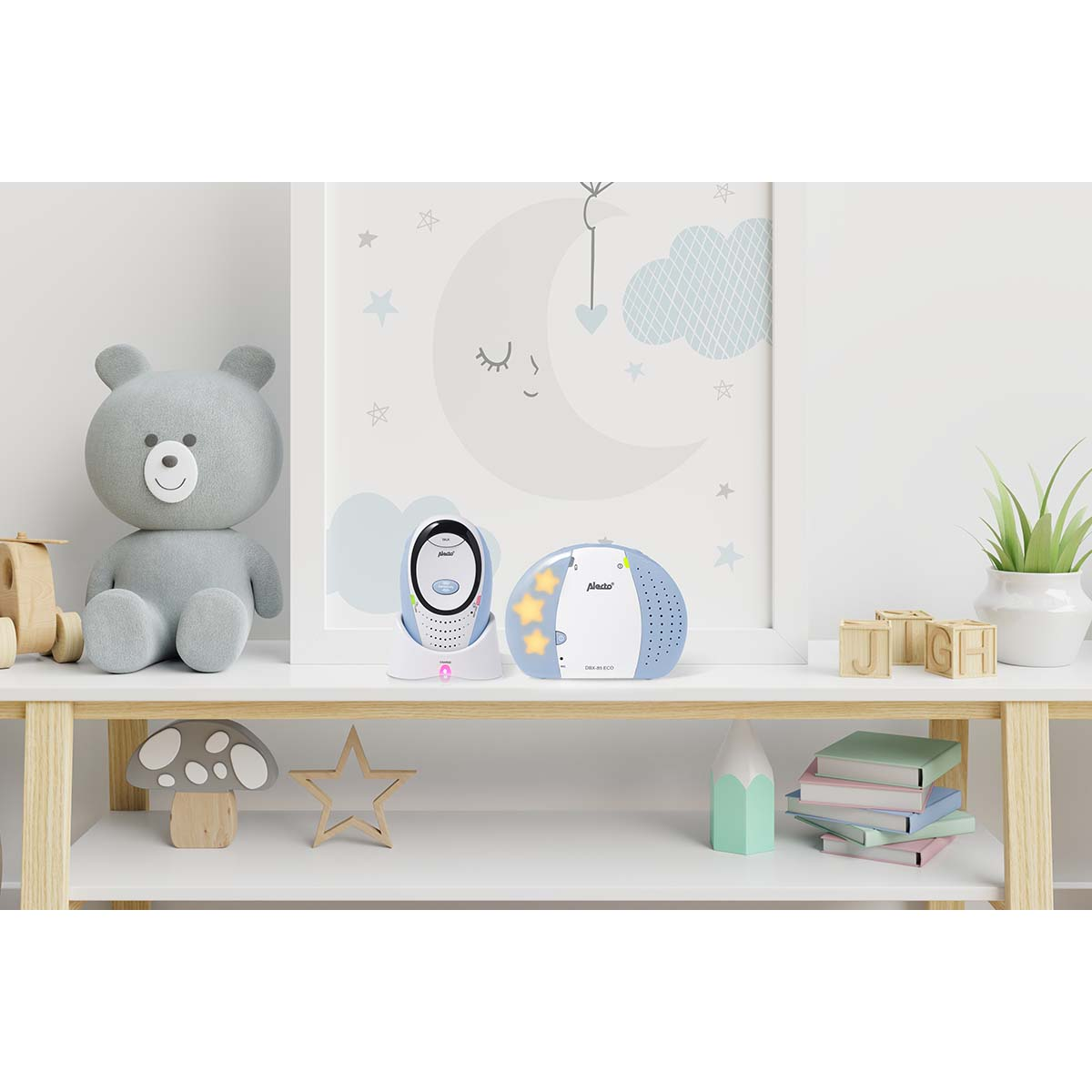 Ein grauer Teddy, ein Babyfon und eine Lampe stehen auf einem Regal.