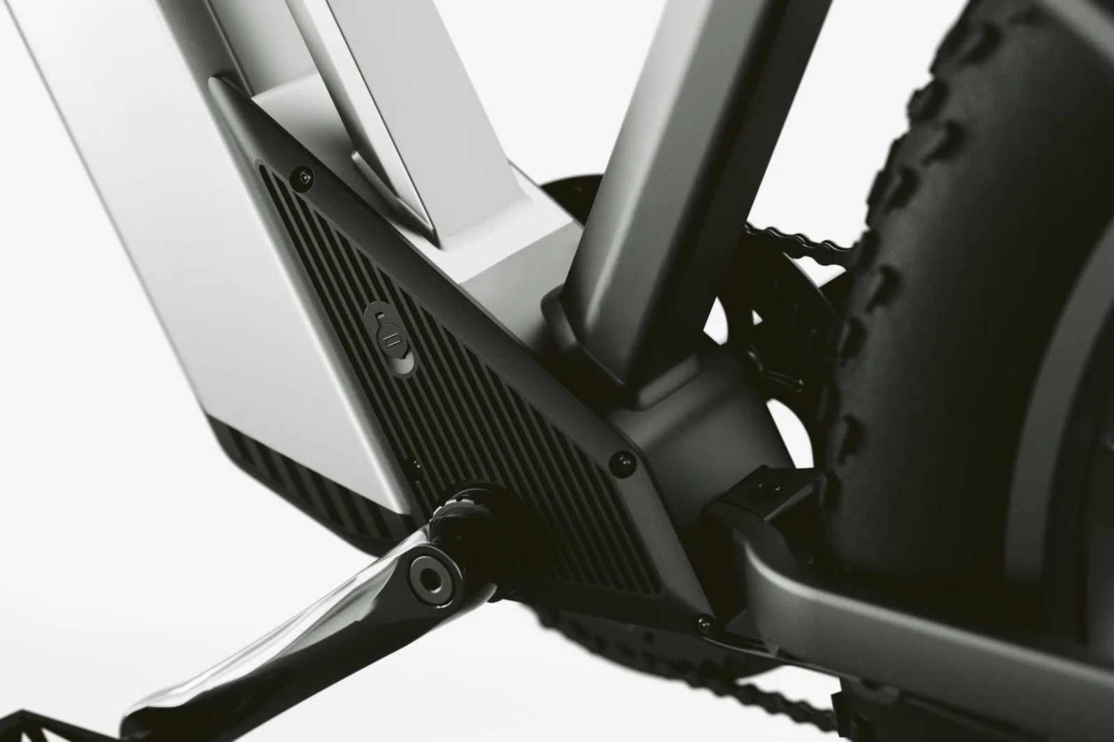 Nahaufnahme des Rahmens eines E-Bikes mit Kurbel, Kette und Reifen.