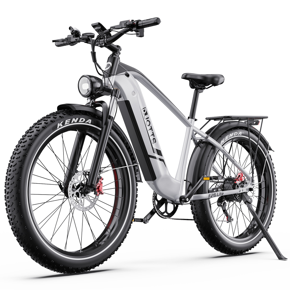 Una bicicleta eléctrica plateada tipo fat bike con llantas negras, sobre fondo blanco.