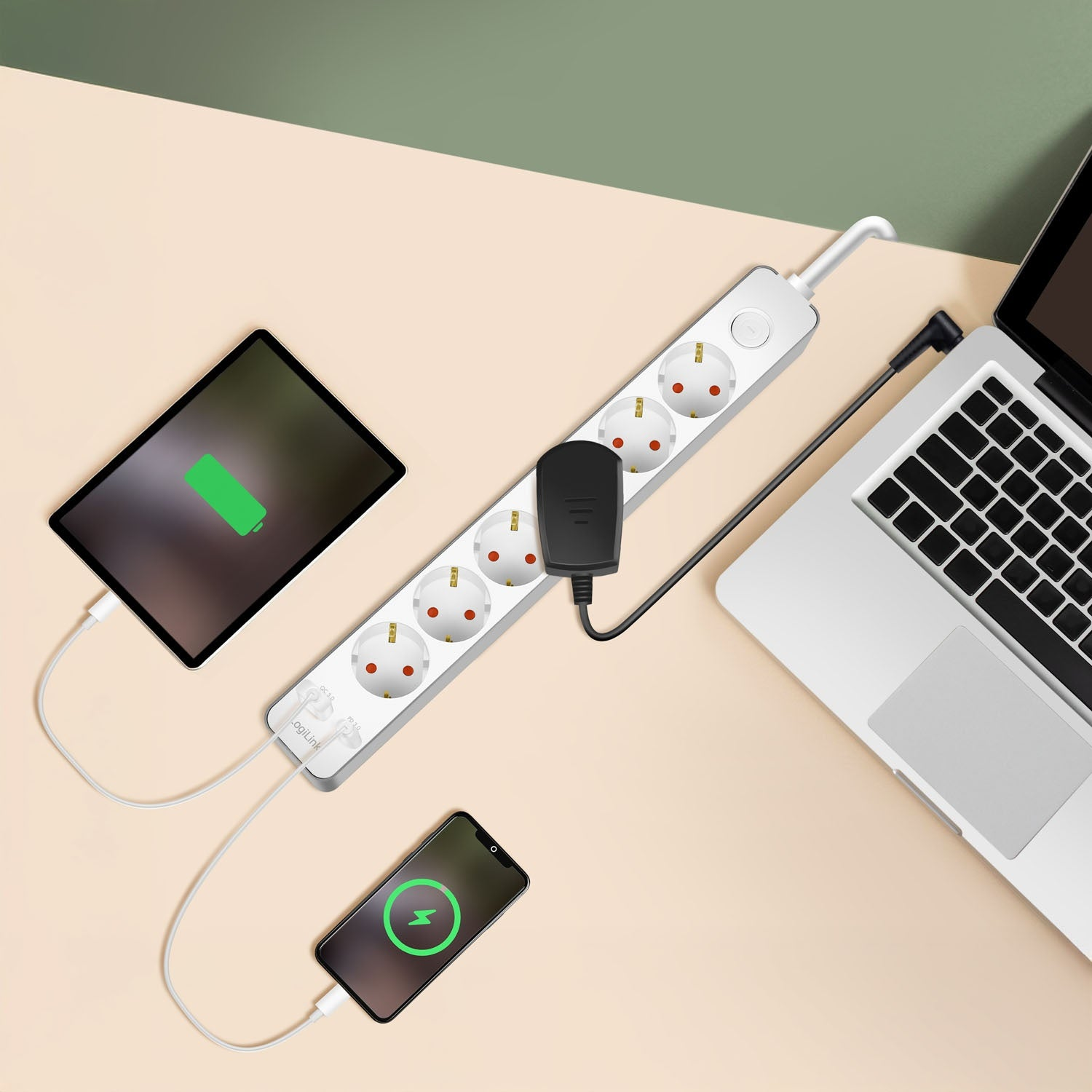 Una regleta carga un portátil, una tableta y un teléfono. Los dispositivos están enchufados.