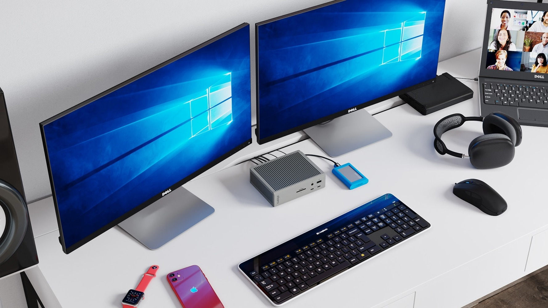 Dual Dell monitors, laptop with video call, keyboard, mouse, headphones, and phone.