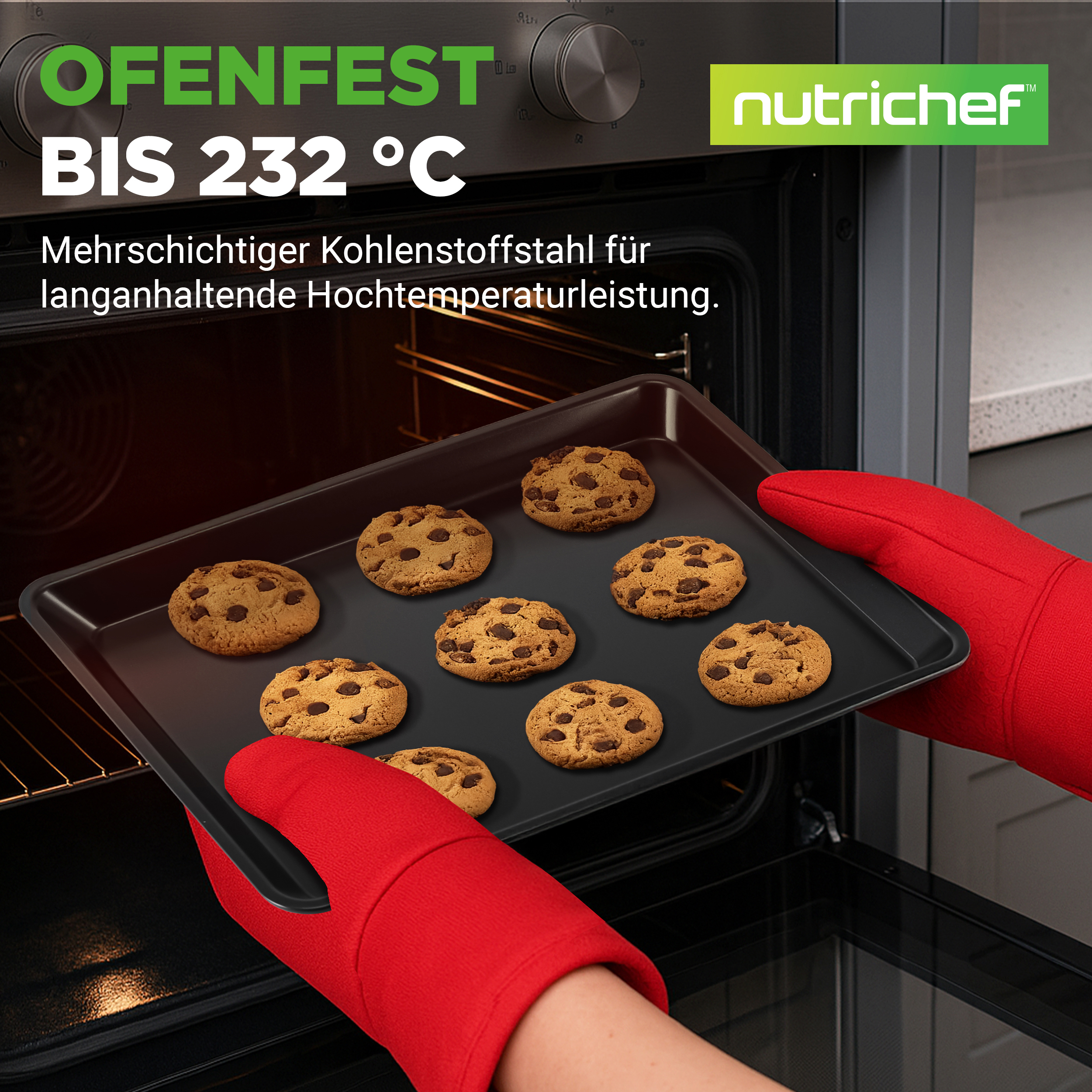 Ein Backblech mit Chocolate Chip Cookies wird von Händen in roten Ofenhandschuhen aus einem Ofen genommen.