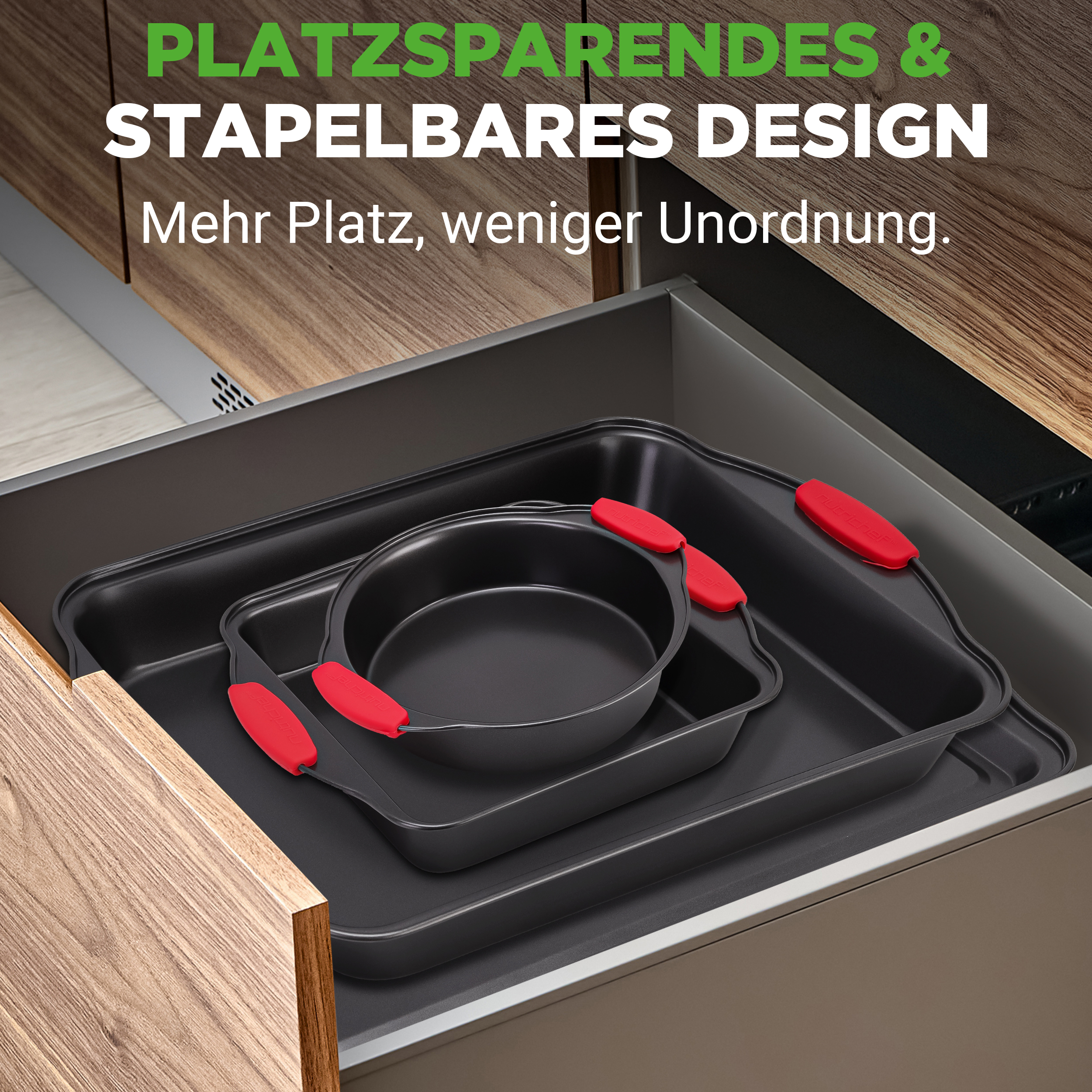 Drei schwarze Backformen mit roten Griffen sind in einer Schublade gestapelt.