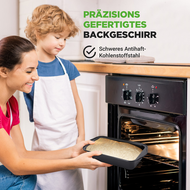 Mutter und Kind blicken in einen Ofen, während sie eine Backform halten.