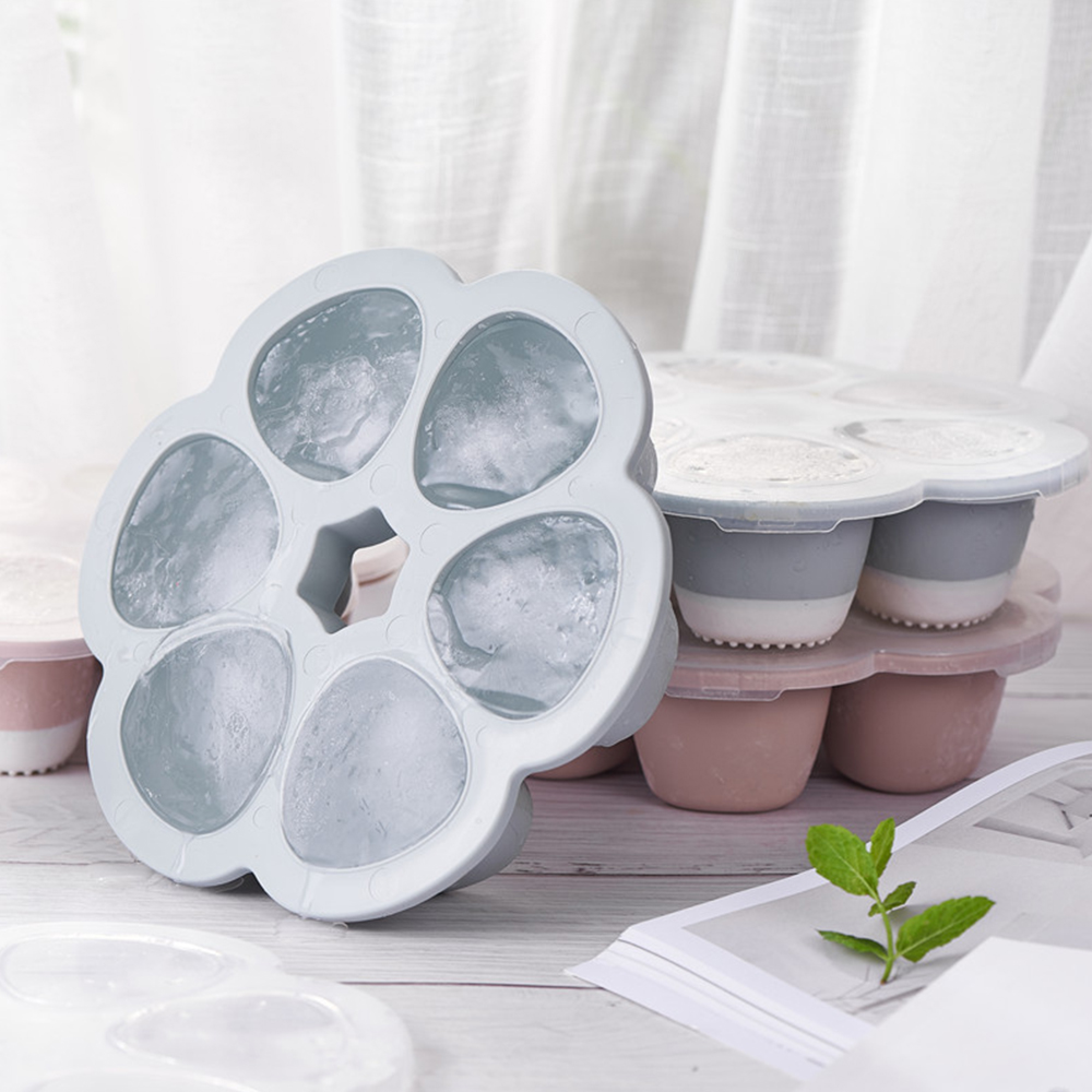 Graue Eiswürfelform mit sechs Fächern, gefüllt mit Eis.