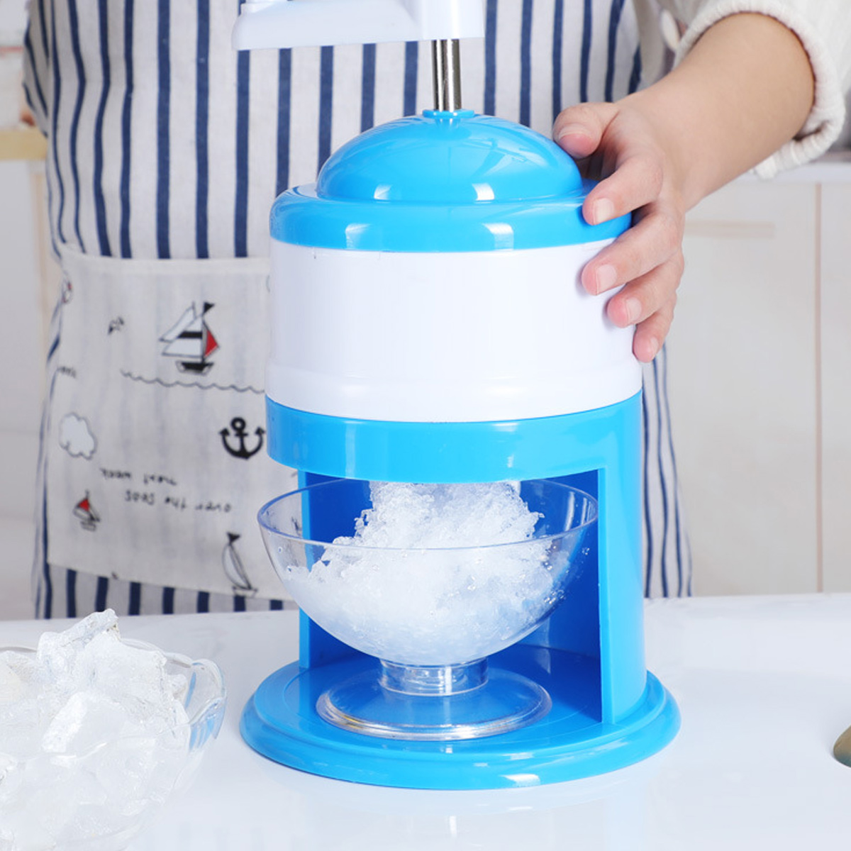 Eine blaue und weiße Eismaschine mit einer Schüssel mit zerstoßenem Eis.