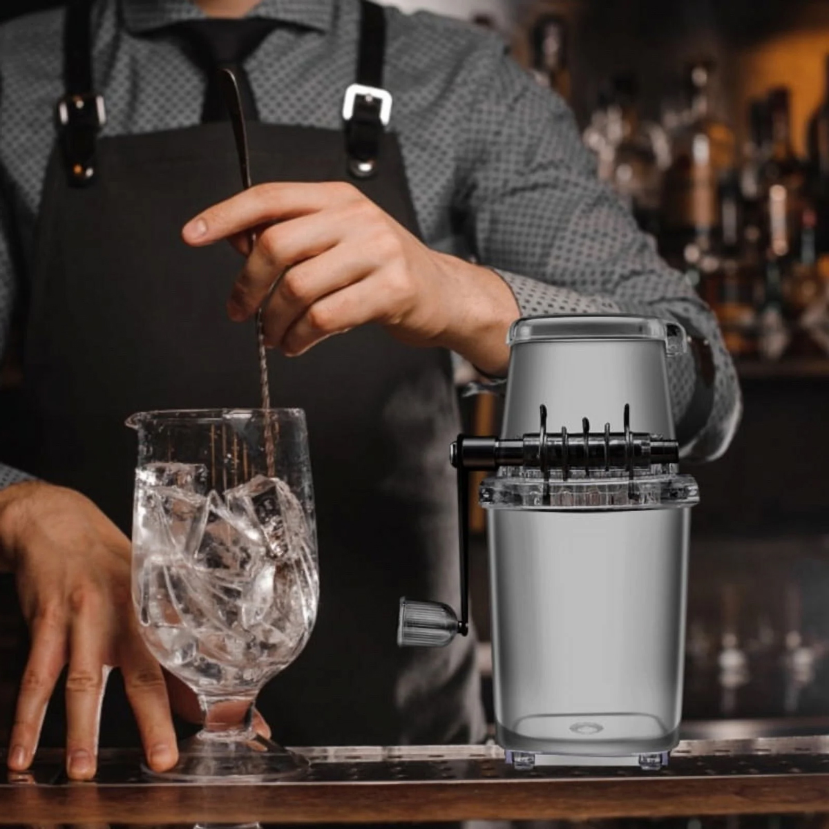 Barkeeper rührt Eis in einem Glas, daneben steht ein Eiscrusher.