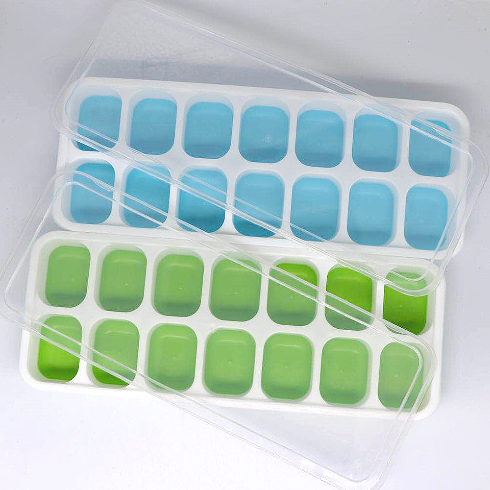 Zwei Eiswürfelformen, eine blau und eine grün, mit Deckeln.