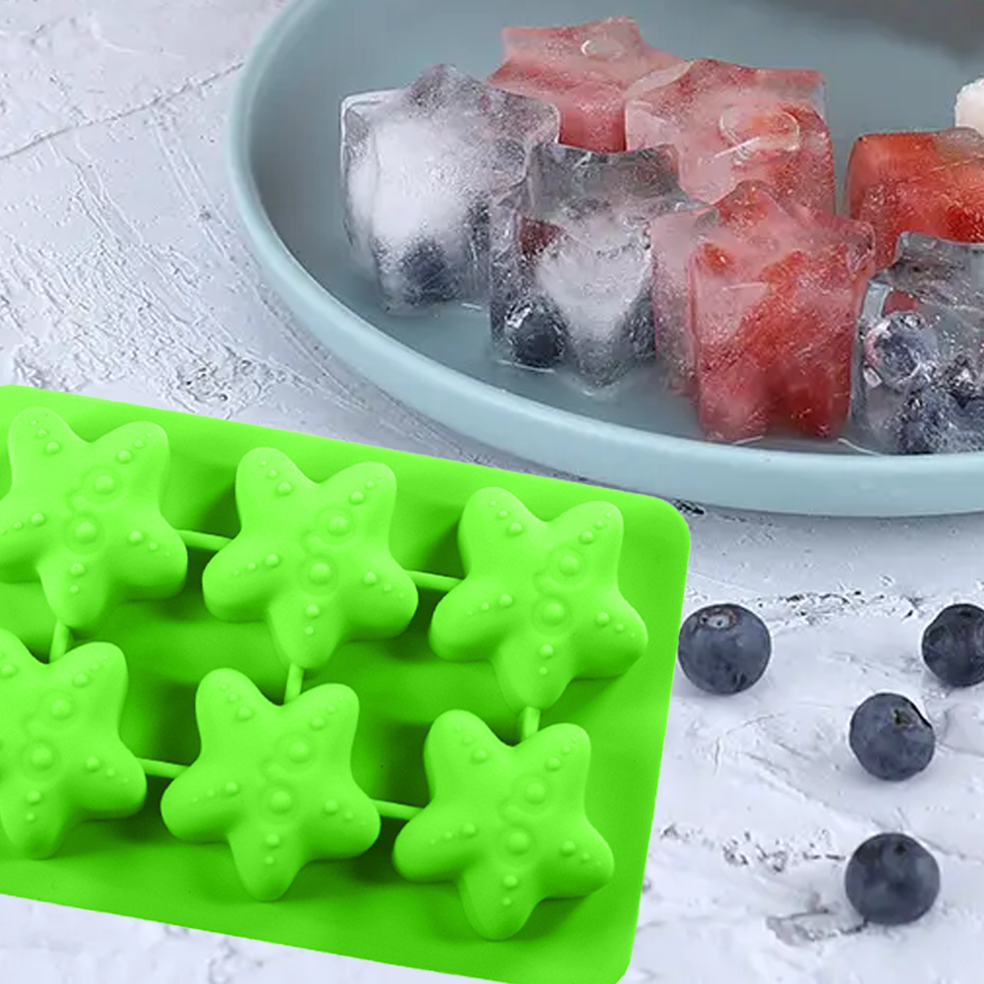 Grüne Seestern-Eiswürfelform mit Eiswürfeln mit Früchten und Blaubeeren.