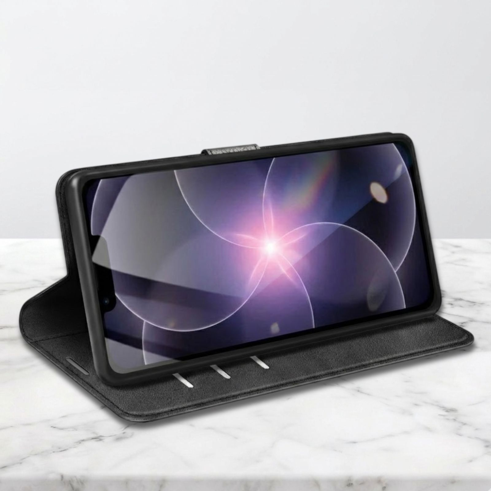 Un teléfono negro con tapa abierta sobre superficie de mármol. La pantalla muestra patrón de luz.