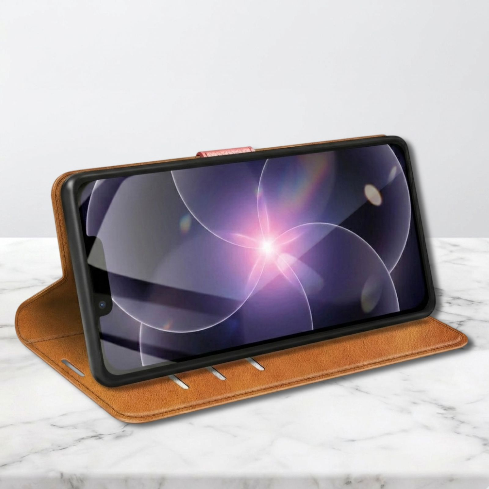 Ein braunes Leder-Flipcase für ein Smartphone, das auf einer Marmoroberfläche liegt.