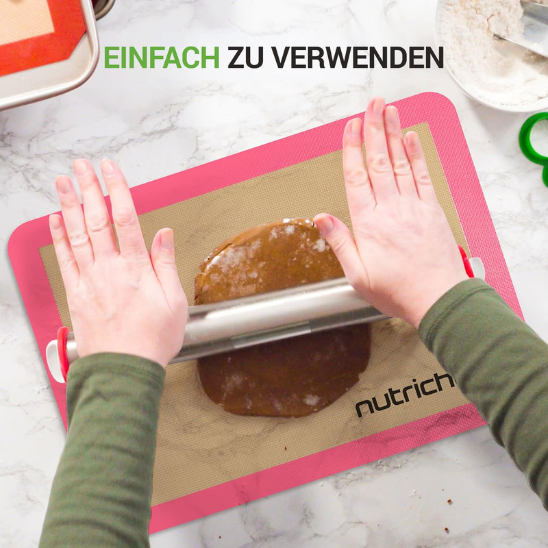 Hände rollen Teig auf einer rosa Matte aus, um ihn zu backen.