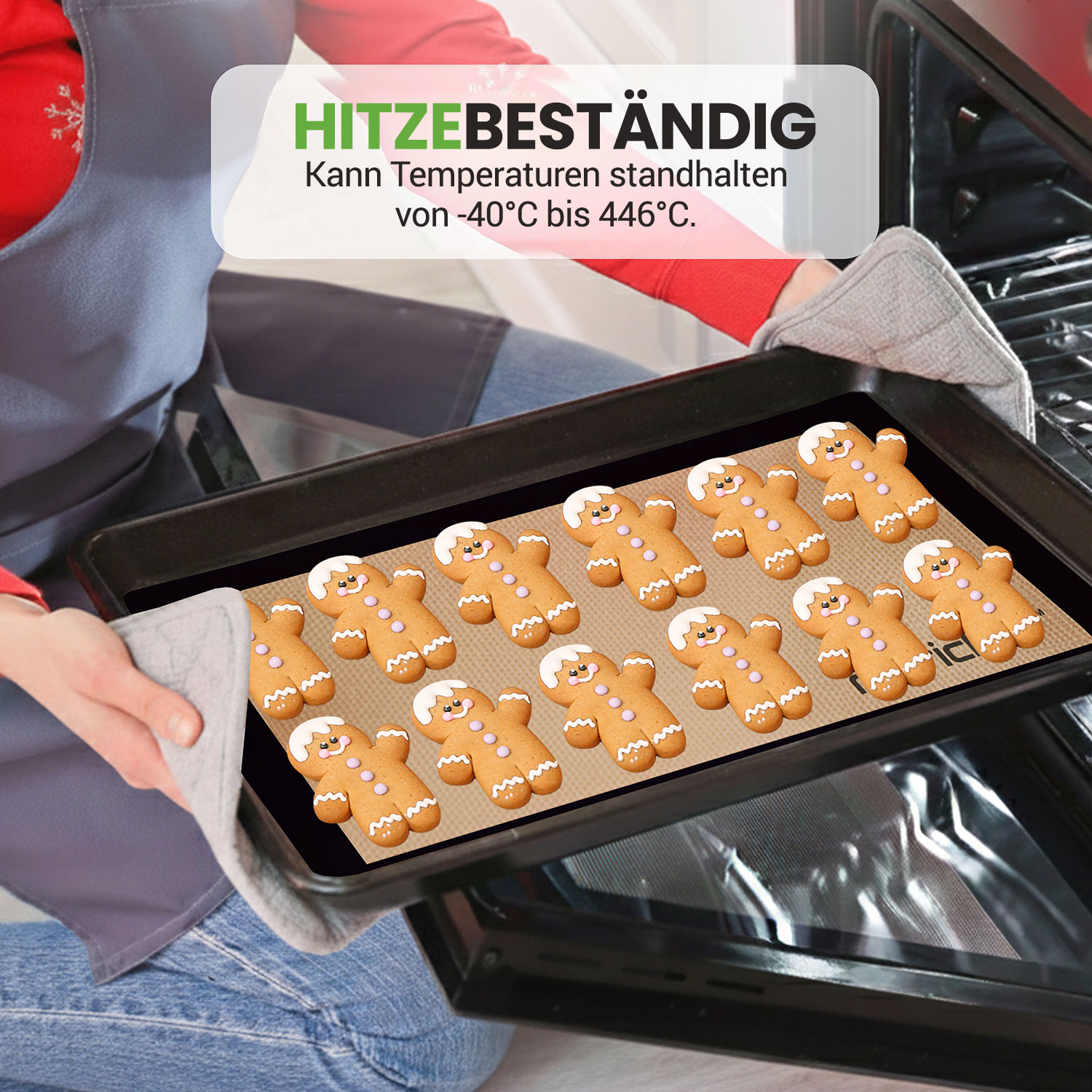Eine Person entnimmt ein Backblech mit Lebkuchenmännchen aus einem Ofen.