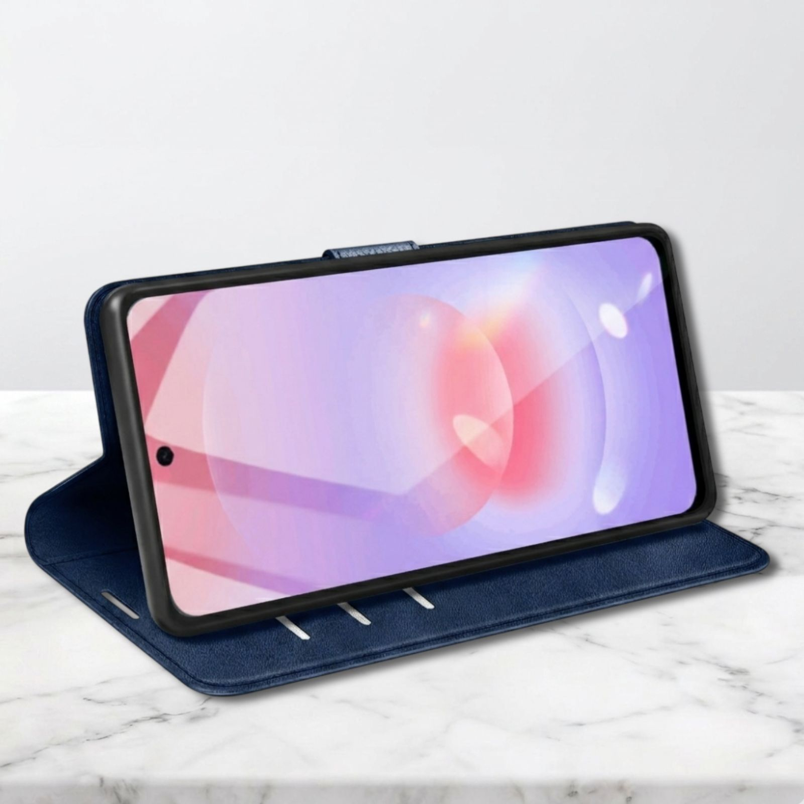Ein dunkelblaues Handycover liegt auf einer Marmoroberfläche. Das Handy ist eingelegt.